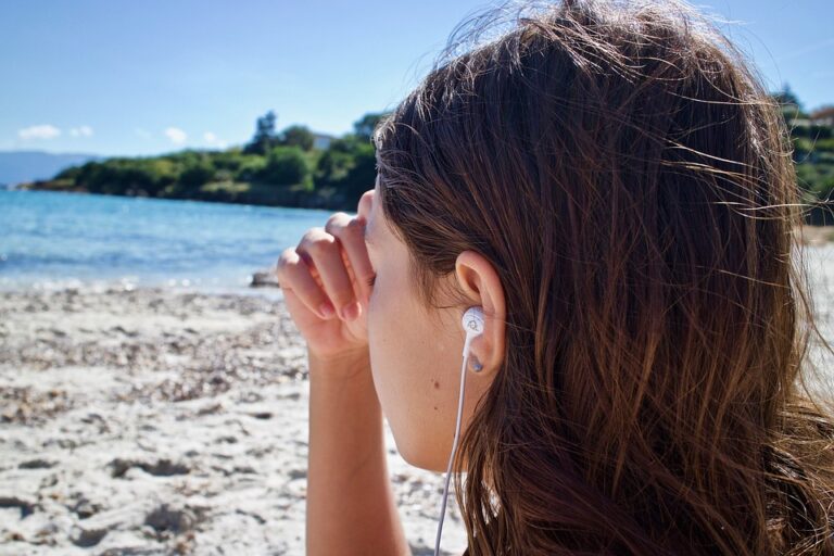 girl with earbuds on beach